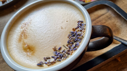 close-up view of delicious aromatic cup of coffee. Latte, cappuccino art, covered with lavender seeds on foam 