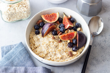 Oatmeal porridge with figs, blueberries, almonds and honey. Healthy eating. Vegetarian food. Breakfast.