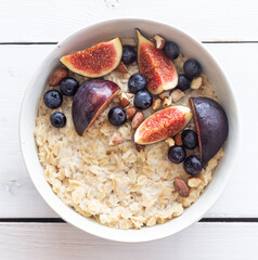 Oatmeal porridge with figs, blueberries, almonds and honey. Healthy eating. Vegetarian food. Breakfast.