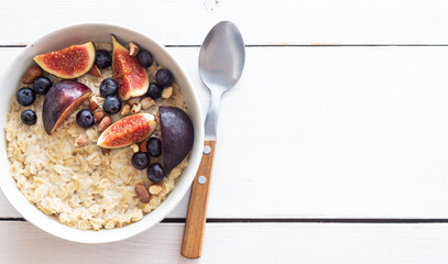 Oatmeal porridge with figs, blueberries, almonds and honey. Healthy eating. Vegetarian food. Breakfast.