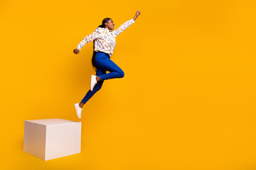 Full length body size view of attractive cheerful girl jumping training isolated over bright yellow...