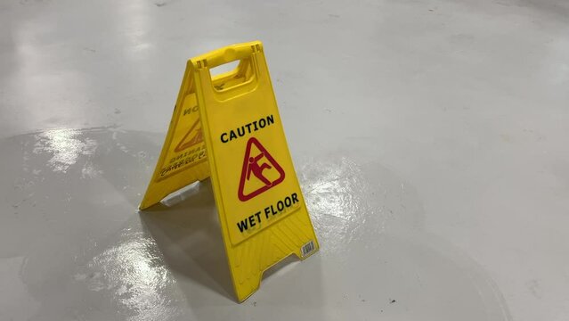 Wet floor sign with a man walking past