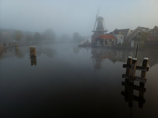 Windmill de Adriaan on a misty morning on the Spaarne River in Haarlem in the Netherlands