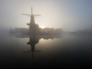 Windmill de Adriaan on a misty morning on the Spaarne River in Haarlem in the Netherlands