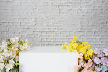 White squre podium with flower decoration for product display with white brick wall background