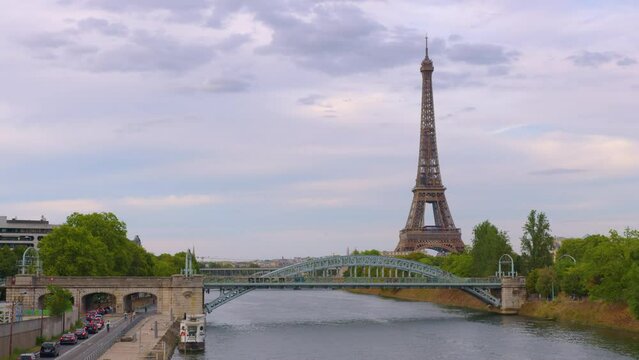 Eiffel Tower on Champs de Mars in Paris, France. Blue cloudy sky at summer day with green lawn