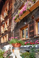 Vertical shot of an old farmhouse with flowers