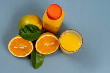 Natural orange juice in the glass with bottle on the side