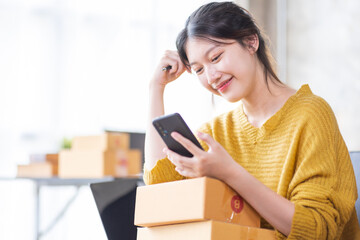 Fototapeta na wymiar Entrepreneur business Asian woman working online SME e-commerce seller at home, Asian woman seller prepare parcel box of product for deliver to customer. Startup Small Business online selling SME idea