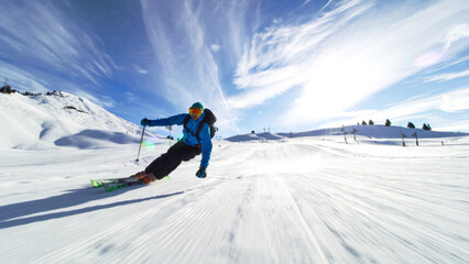 professional skier skiing on slopes in the Swiss alps towards the camera - obrazy, fototapety, plakaty