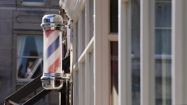 Barbers Pole sign spinning on the side of shop
