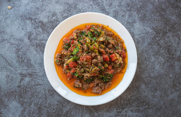 Ground beef, onion, tomato and paprika and a bowl of delicious spicy hot pepper con carne.