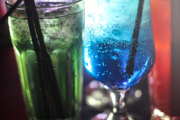 delicious creative bright cocktails booze alcohol with a straw are on the table in a club or a lighted bar