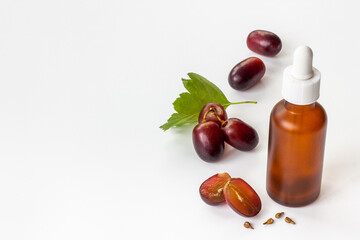 Bottle of grape seed essential oil with grapes. Eco cosmetic product