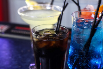 delicious creative bright cocktails booze alcohol with a straw are on the table in a club or a lighted bar