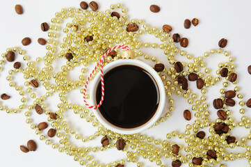Christmas New Year coffee concept. Cup of black espresso coffee decorated as christmas tree ball. Golden Christmas tree beads. White background