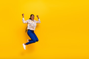 Full length body size view of attractive cheerful girl jumping rejoicing isolated over bright yellow color background
