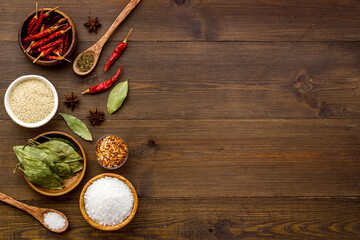 Colorful herbs and spices in bowls for cooking. Pepper chili, laurel leaf, salt and curry