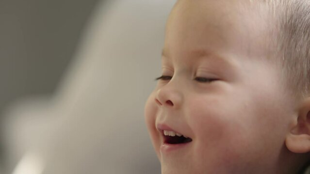 baby boy portrait watching tv showing face emotions child facial expressions close-up. cute caucasian male kid child face. little boy openes mouth smiling lips look side view. Worrying baby face 