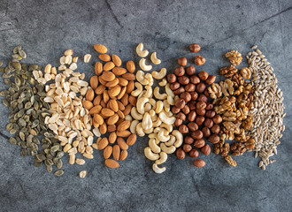 Mix of nuts on a dark background. Food backdrop with nuts and seeds.