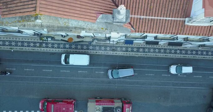 aerial top down view over the million stars in Lisbon. Amazing portuguese coblestone history morning early. some cars crossing the line.