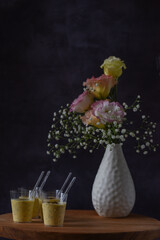 mousse de maracujá em pequenos copos. Doce de festa em ambiente decorado com flores. espaço para texto.