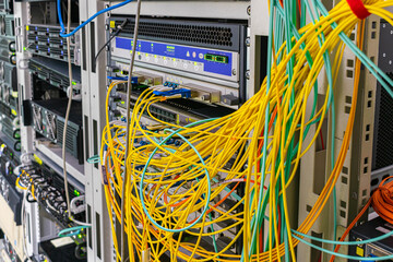 There is a rack with network equipment in the server room. There are a lot of messy wires on the...