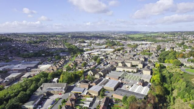 Aerial drone footage of the town of Heckmondwike which is a district in West Yorkshire, England UK, showing residential housing estates, and semi detached houses in the summer time.