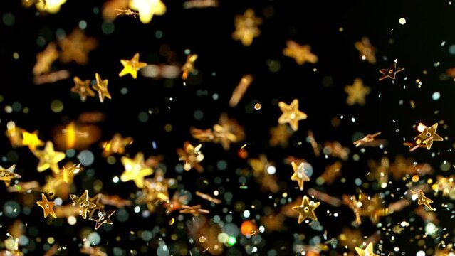 Super slow motion of abstract gold stars particles on black background. Filmed on high speed cinematic camera at 1000 frames per second.