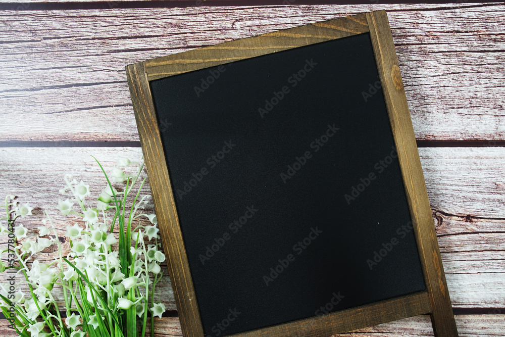 Poster empty chalkboard mockup space for text message with flower decoration top view on wooden background
