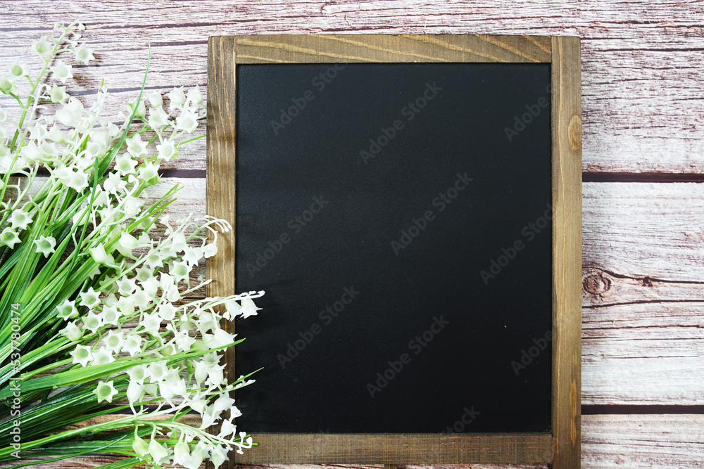 Poster empty chalkboard mockup space for text message with flower decoration top view on wooden background