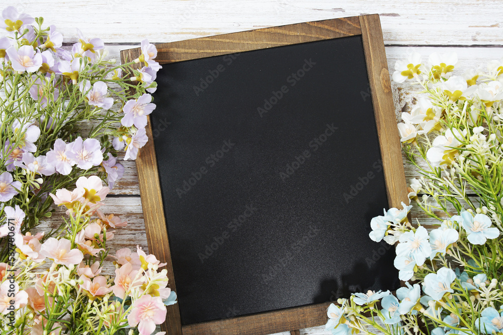 Poster empty chalkboard mockup space for text message with flower decoration top view on wooden background