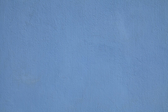 Navy blue or sapphirine wall, texture, background. The building wall, painted with water-based paint. Smooth (flat) surface in blue color with a little stains or dust. Bluish backdrop