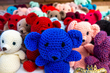 Knitted teddy bears in colourful colours ready to give out as gifts to children.