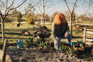 mid adult woman gardening in her backyard garden