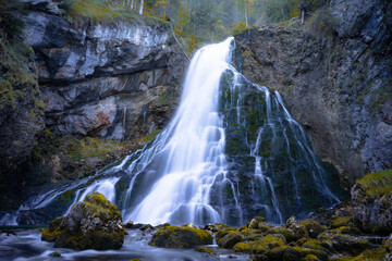Fototapeta na wymiar Beautiful fall waterfall with mirrored water 