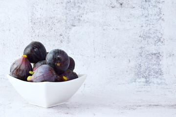 Fruit, figs in white porcelain bowl, front shot and copy space.