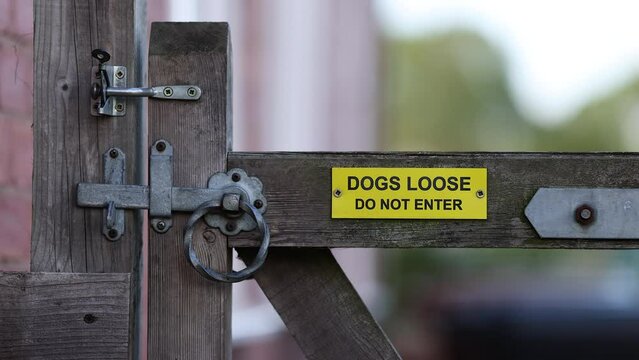 Gate with dogs loose do not enter sign close up