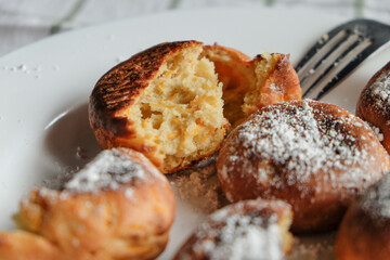 Scones on a white plate with fork. On a white checkered towel. Top view