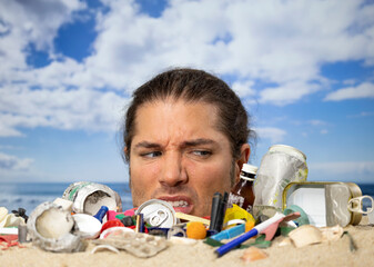 Man buried in sand on beach with rubbish