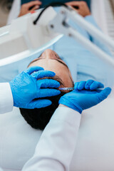 Handsome middle age man receiving advanced Platelet Rich Plasma PRP treatment against hair loss....