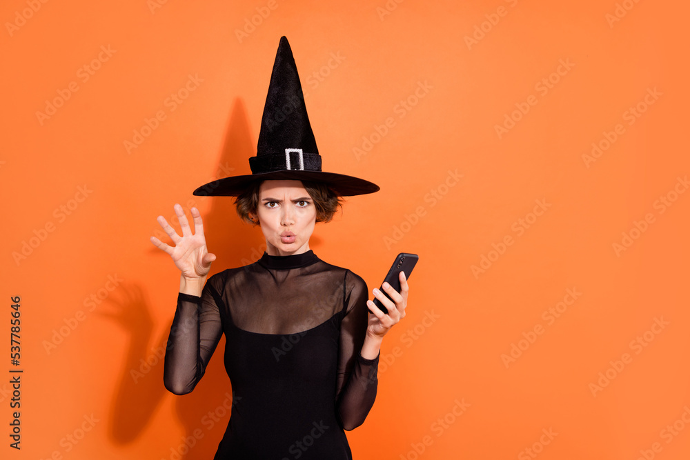 Wall mural Photo of attractive terrifying lady hold telephone arm make scary boo gesture isolated on orange color background - Wall murals
