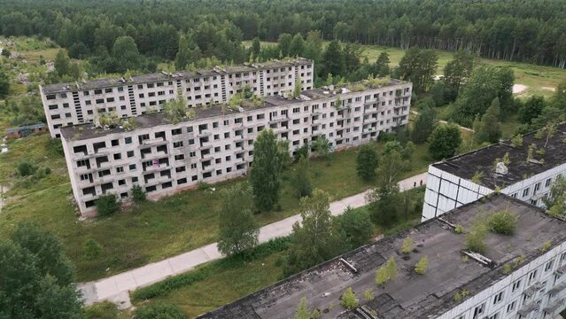 Irbene, Latvia - Aerial drone flight over the soviet buildings of the ghost town Irbene with collapsing soviet buildings and settlement for military officers and their families - 2022 bird view