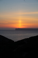 mystical sunset by the sea with a section of coast	