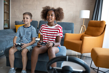 Caucasian boy and afro american girl playing playstation game