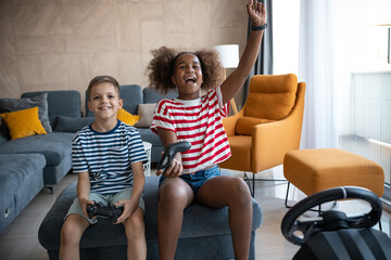 Caucasian boy and afro american girl playing playstation game