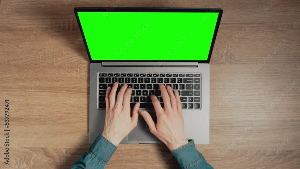 Poster closeup a man hands are typing on laptop keyboard with green screen. place for pasting content on ch