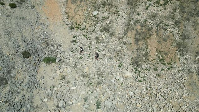 Aerial view of two hikers on an arid mountain in Arrabida Natural Park, Sesimbra, Portugal