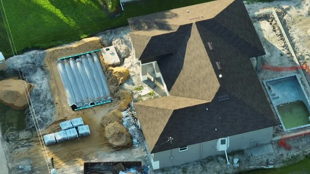 Aerial view of suburban private house with yard ground works, septic drain field installation and swimming pool under construction in Florida quiet rural area