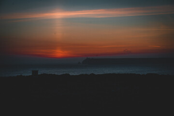 mystical sunset by the sea with a section of coast	